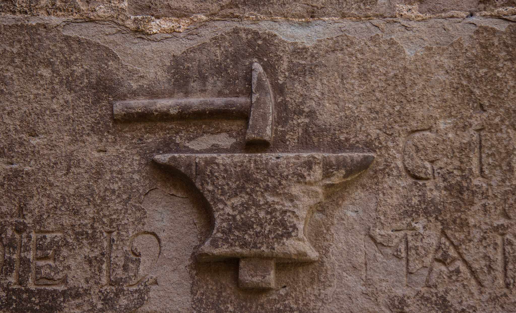 A blacksmith logo etched in stone