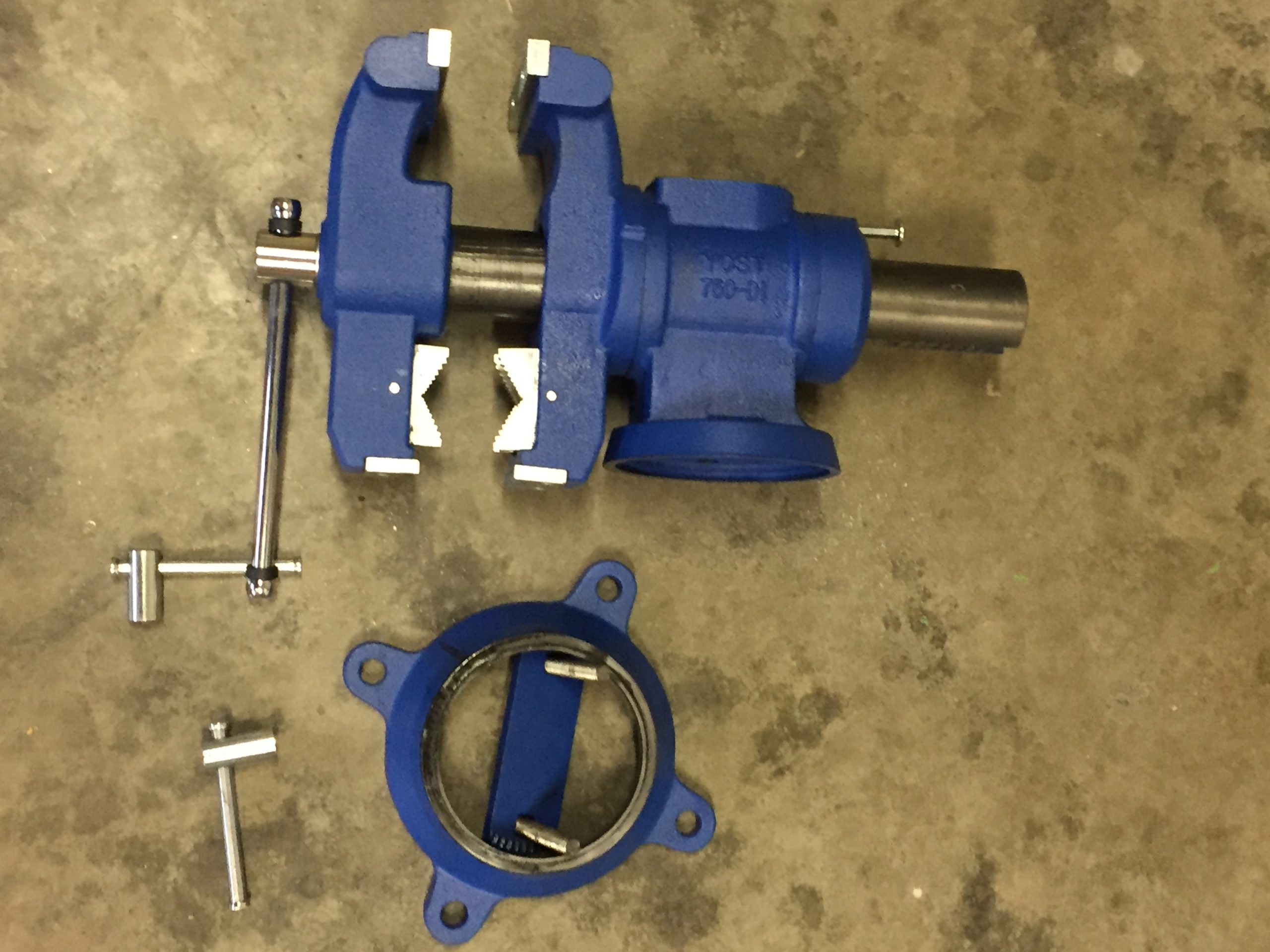 an image showing a disassembled multi jaw swivel vise on concrete