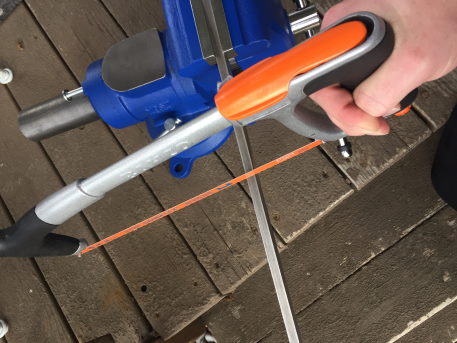 an image of a hacksaw sawing a piece of steel trapped in a vise