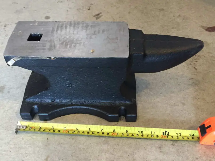 a picture of a 55lb cast iron anvil with a measuring tape measuring it's length