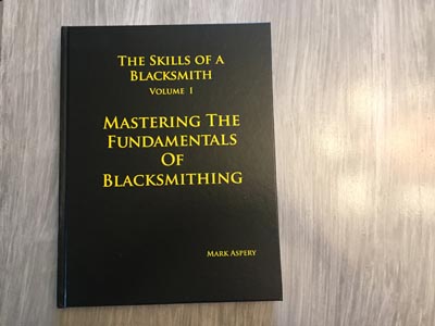 A picture of the front cover of "The skills of a blacksmith Volume 1: Mastering the fundamentals of blacksmithing" by Mark Aspery.